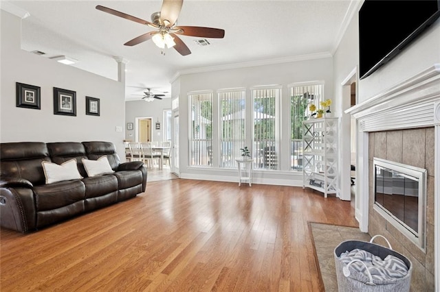 101 Tammy Dr, Slidell, LA 70458 - living area with a ceiling fan, a tiled fireplace, wood finished floors, and ornamental molding