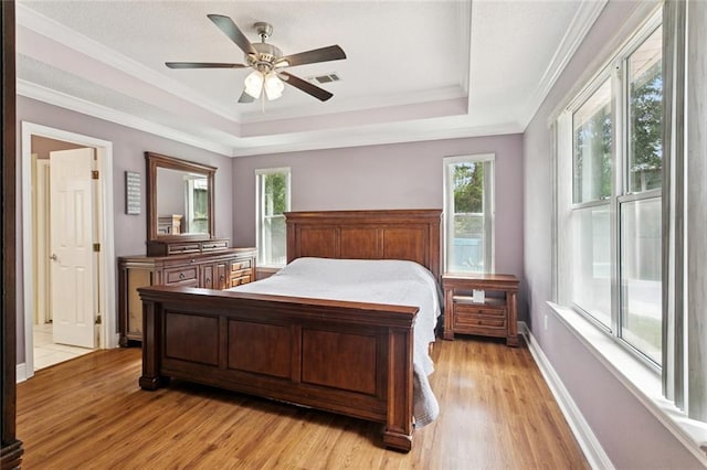 101 Tammy Dr, Slidell, LA 70458 - bedroom featuring multiple windows, light wood finished floors, ornamental molding, and a tray ceiling