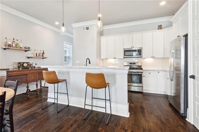 2909 Amelia St, New Orleans, LA 70115 - kitchen with stainless steel appliances, ornamental molding, white cabinetry, a breakfast bar area, and decorative backsplash
