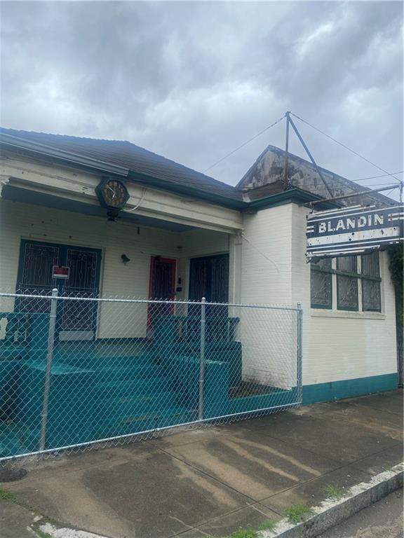 1122 Henriette Delille St, New Orleans, LA 70116 - view of side of property featuring a fenced front yard and brick siding