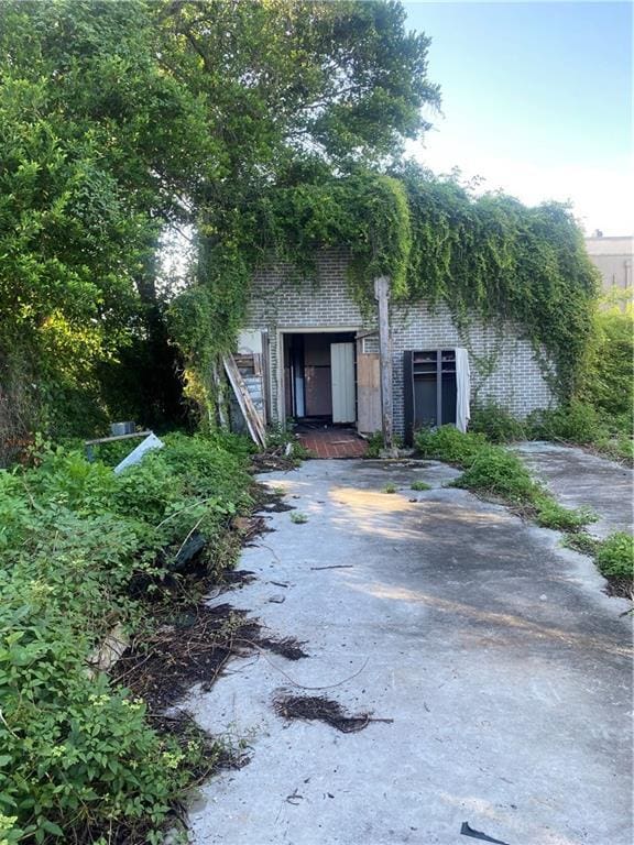 1122 Henriette Delille St, New Orleans, LA 70116 - view of property hidden behind natural elements featuring brick siding