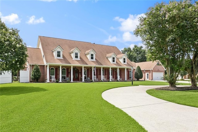 299 Sarah Victoria Dr, Belle Chasse, LA 70037 - cape cod house featuring covered porch, a front yard, and curved driveway