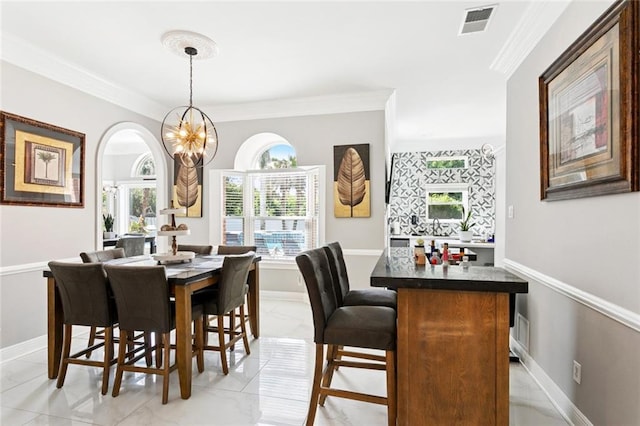 299 Sarah Victoria Dr, Belle Chasse, LA 70037 - dining room with ornamental molding, light marble finish flooring, healthy amount of natural light, arched walkways, and a chandelier