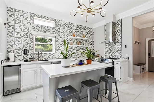 299 Sarah Victoria Dr, Belle Chasse, LA 70037 - kitchen with appliances with stainless steel finishes, light marble finish floors, wall chimney range hood, light countertops, and ornamental molding