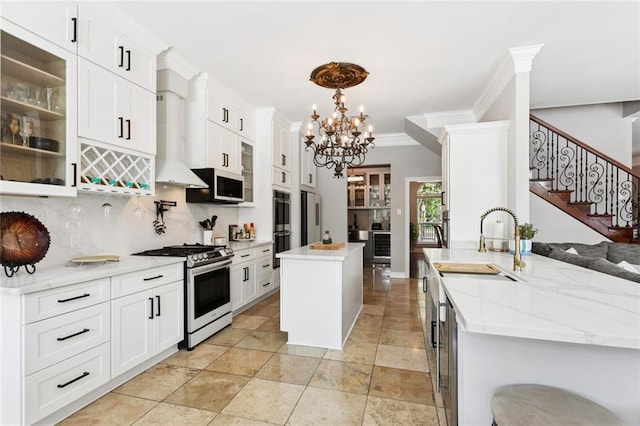 299 Sarah Victoria Dr, Belle Chasse, LA 70037 - kitchen with appliances with stainless steel finishes, backsplash, a chandelier, glass insert cabinets, and a center island