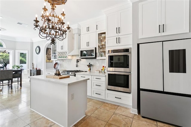 299 Sarah Victoria Dr, Belle Chasse, LA 70037 - kitchen featuring stainless steel appliances, a kitchen island, light countertops, ornamental molding, and a chandelier