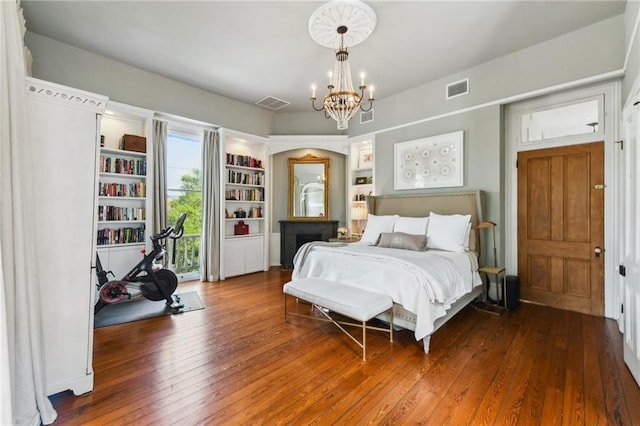 639 Esplanade Ave, New Orleans, LA 70116 - bedroom featuring wood-type flooring, a chandelier, and access to exterior