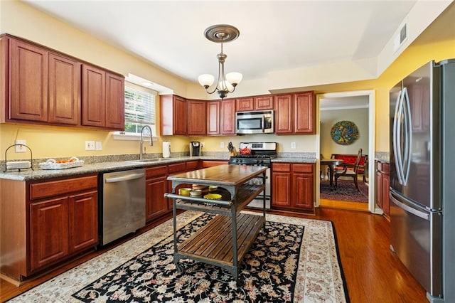 4519 Bancroft Dr, New Orleans, LA 70122 - kitchen with stainless steel appliances, pendant lighting, dark wood-type flooring, and a chandelier