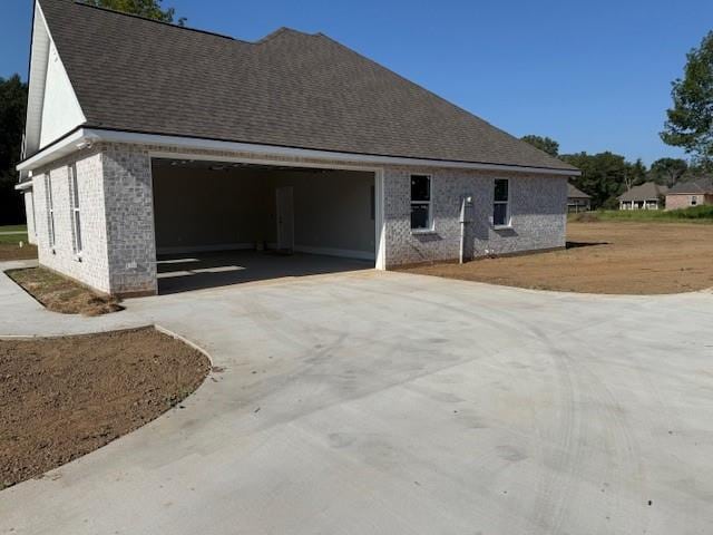 53357 Phillips Path, Loranger, LA 70446 - view of side of property with driveway, brick siding, an attached garage, and roof with shingles