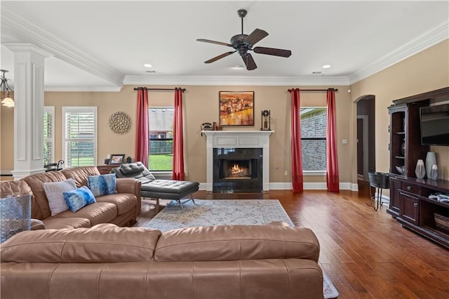 1521 Rue De Fontaine, Covington, LA 70433 - living area featuring a ceiling fan, dark wood finished floors, arched walkways, a fireplace with flush hearth, and ornamental molding