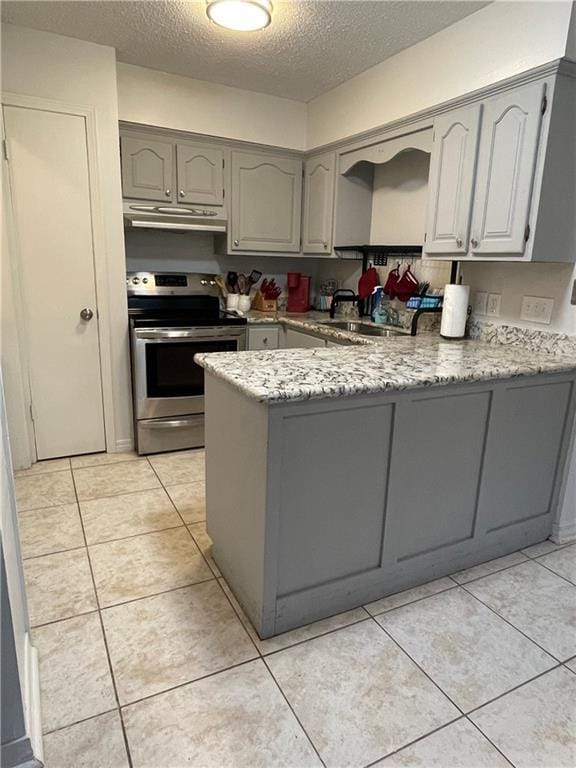 51 Brandon Hall Dr, Destrehan, LA 70047 - kitchen featuring stainless steel electric range oven, under cabinet range hood, a peninsula, gray cabinetry, and a textured ceiling