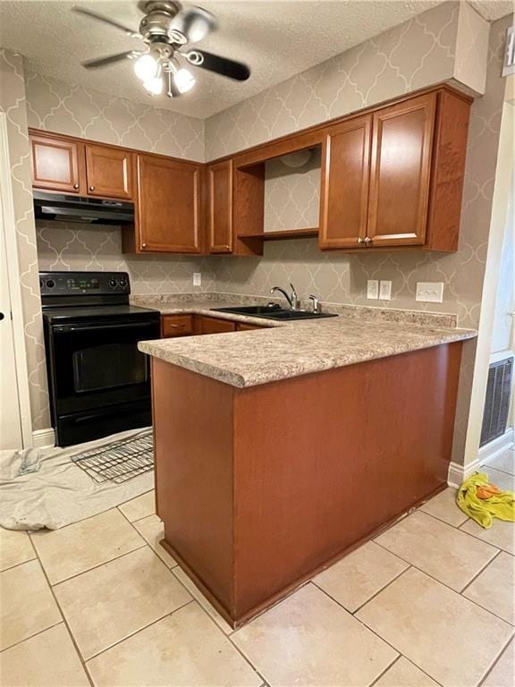 51 Brandon Hall Dr, Destrehan, LA 70047 - kitchen featuring black electric range oven, under cabinet range hood, a peninsula, brown cabinets, and light countertops