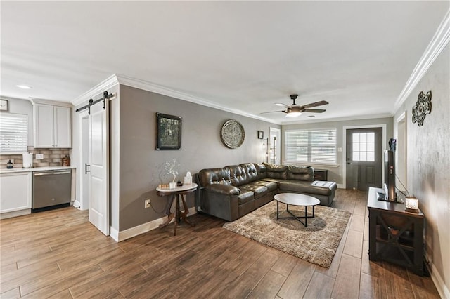 5028 Jasper St, Metairie, LA 70006 - living room with a barn door, ceiling fan, light wood-style flooring, and crown molding