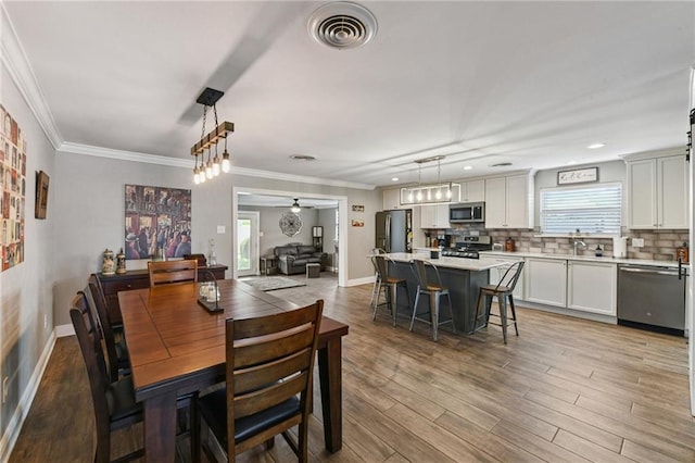 5028 Jasper St, Metairie, LA 70006 - dining space featuring a ceiling fan, light wood finished floors, ornamental molding, and recessed lighting