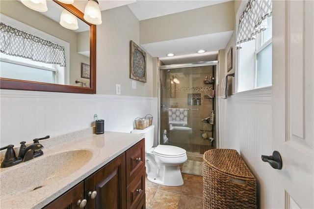 5028 Jasper St, Metairie, LA 70006 - bathroom featuring vanity, a stall shower, wainscoting, healthy amount of natural light, and stone finish flooring