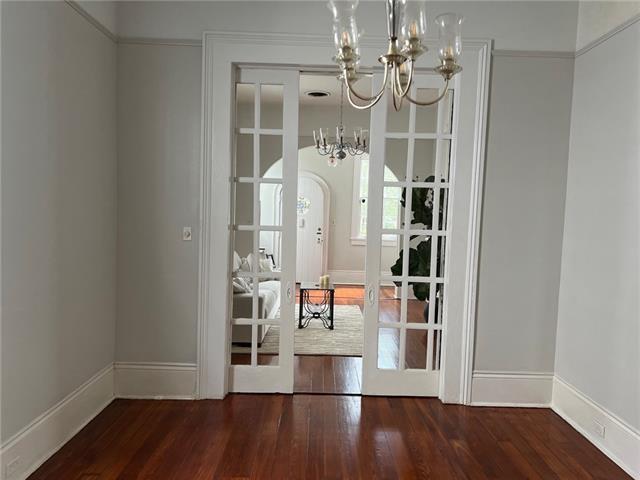 400 Millaudon St, New Orleans, LA 70118 - unfurnished dining area with a chandelier, wood finished floors, and arched walkways