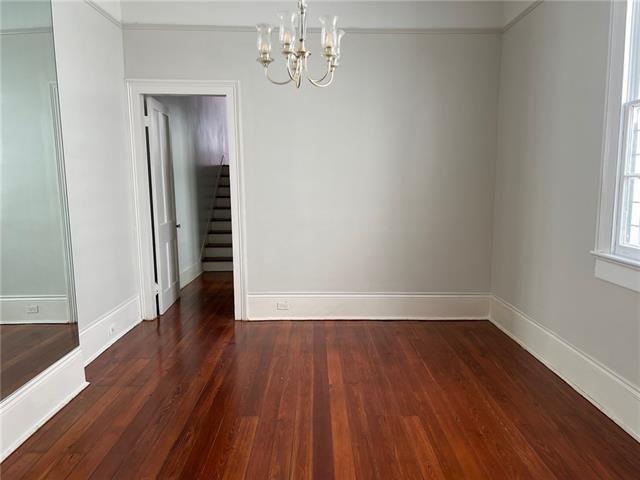 400 Millaudon St, New Orleans, LA 70118 - unfurnished dining area with a chandelier, dark wood-style floors, and stairway