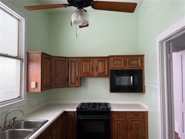 400 Millaudon St, New Orleans, LA 70118 - kitchen with black appliances, ceiling fan, and light countertops