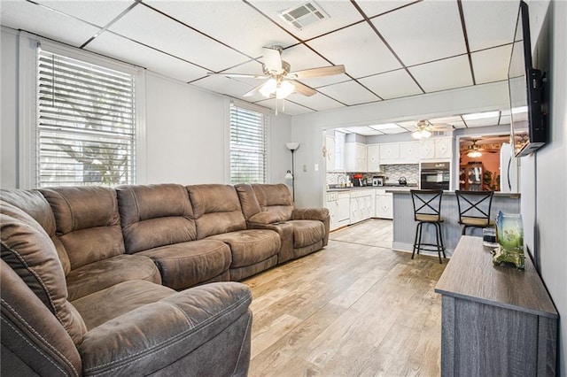 5225 Conti St, New Orleans, LA 70124 - living area featuring a ceiling fan, a paneled ceiling, and light wood-style flooring