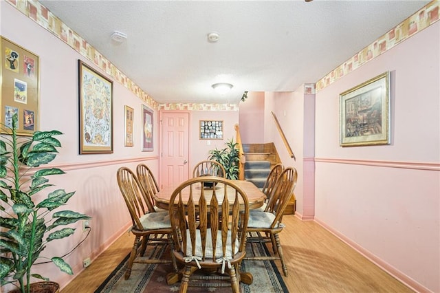 5225 Conti St, New Orleans, LA 70124 - dining room featuring stairway, wood finished floors, and a textured ceiling