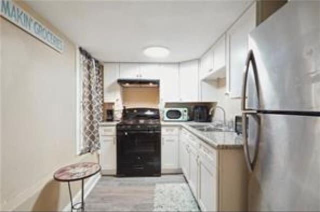 3026 Short St, New Orleans, LA 70125 - kitchen featuring freestanding refrigerator, range, ventilation hood, light wood-style floors, and white cabinetry