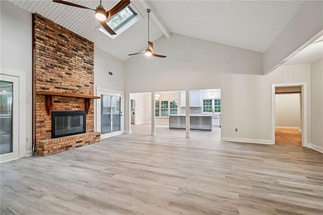 325 Jasmine Dr, Mandeville, LA 70471 - unfurnished living room with a ceiling fan, high vaulted ceiling, light wood-style flooring, beam ceiling, and a brick fireplace