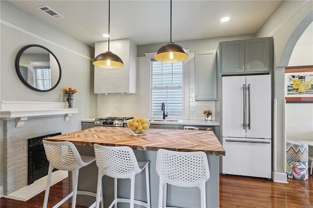 2303 Wisteria St, New Orleans, LA 70122 - kitchen with wood counters, high end white fridge, backsplash, dark wood-style flooring, and range