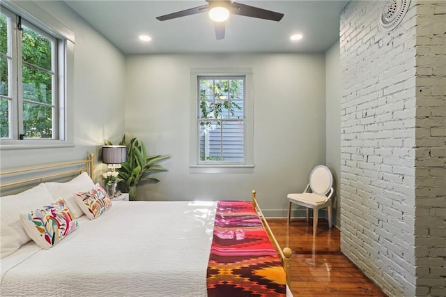 2303 Wisteria St, New Orleans, LA 70122 - bedroom with wood finished floors, multiple windows, brick wall, ceiling fan, and recessed lighting