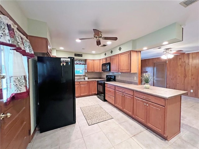 6012 Bridget St, Metairie, LA 70003 - kitchen featuring black appliances, a ceiling fan, a peninsula, light countertops, and wooden walls