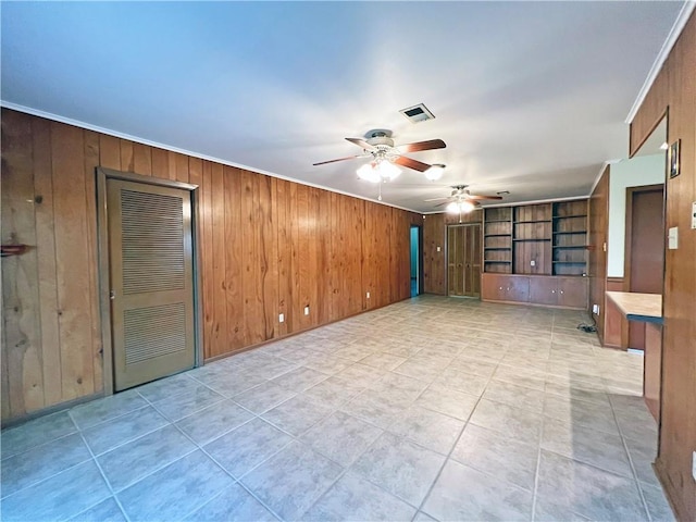 6012 Bridget St, Metairie, LA 70003 - empty room with ceiling fan, wood walls, ornamental molding, and light tile patterned floors