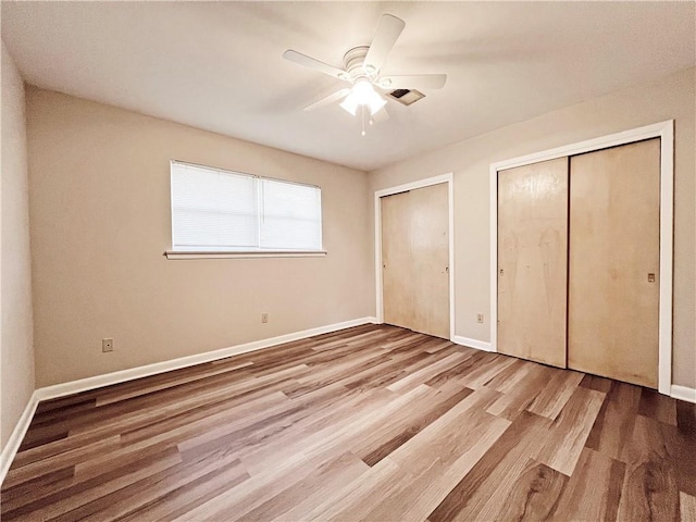 6012 Bridget St, Metairie, LA 70003 - unfurnished bedroom with two closets, wood finished floors, and a ceiling fan