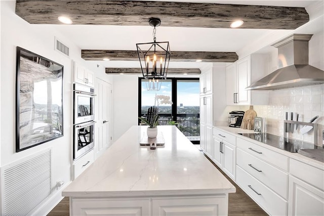 300 Lake Marina Ave Unit 14Dbw, New Orleans, LA 70124 - kitchen with wall chimney range hood, black electric cooktop, dark wood-style flooring, a center island, and beamed ceiling