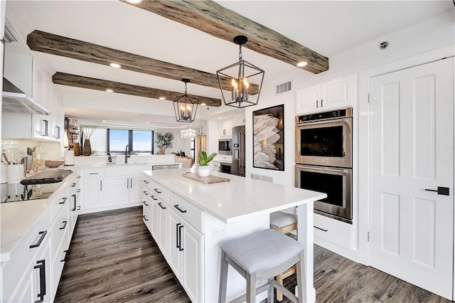 300 Lake Marina Ave Unit 14Dbw, New Orleans, LA 70124 - kitchen featuring stainless steel appliances, a chandelier, a kitchen bar, dark wood-type flooring, and beamed ceiling
