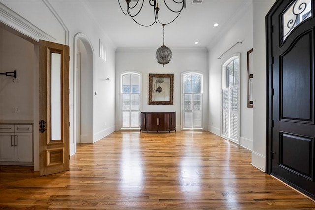 6978 Canal Blvd, New Orleans, LA 70124 - entrance foyer with arched walkways, ornamental molding, wood finished floors, a chandelier, and recessed lighting
