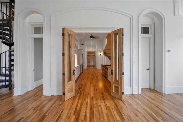 6978 Canal Blvd, New Orleans, LA 70124 - hall featuring light wood-style floors, stairway, and arched walkways