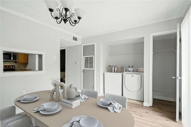 10286 W Winston Ave Unit 15, Baton Rouge, LA 70809 - dining space with ornamental molding, a chandelier, washer and clothes dryer, and light wood-style floors
