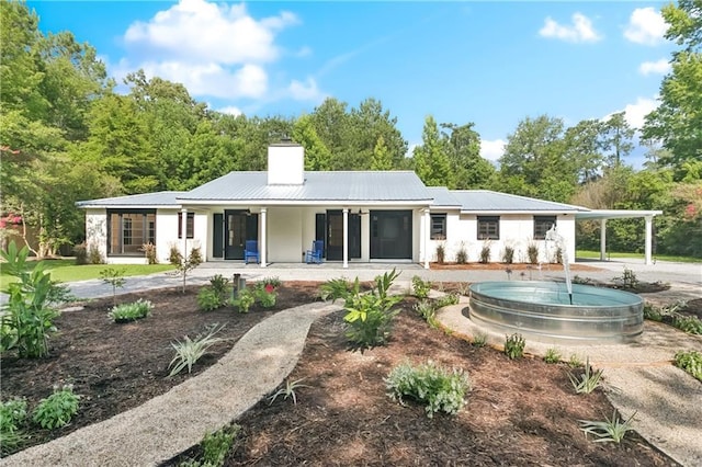 72287 Military Rd, Covington, LA 70435 - rear view of property with a porch, a chimney, and a metal roof