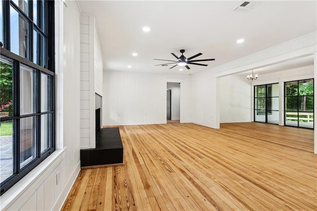 72287 Military Rd, Covington, LA 70435 - unfurnished living room featuring a large fireplace, a chandelier, light wood finished floors, a ceiling fan, and recessed lighting