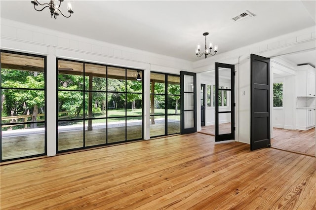 72287 Military Rd, Covington, LA 70435 - empty room featuring a chandelier and light wood-style flooring