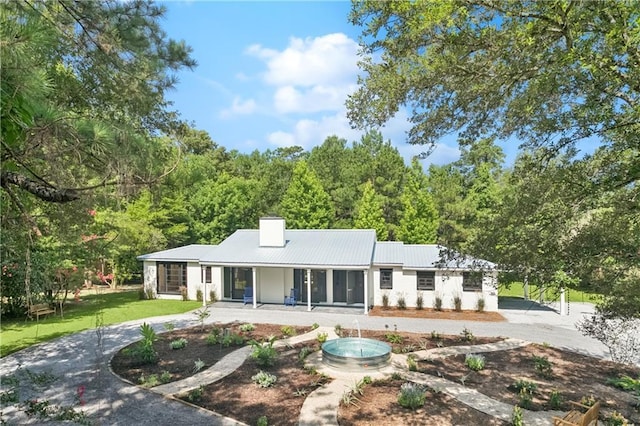 72287 Military Rd, Covington, LA 70435 - back of property with a chimney, a metal roof, a yard, and curved driveway