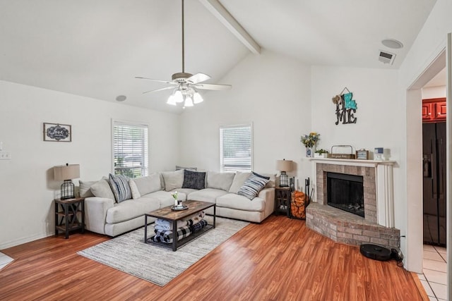 70105 10th St, Covington, LA 70433 - living room with light wood finished floors, beam ceiling, a ceiling fan, a brick fireplace, and high vaulted ceiling