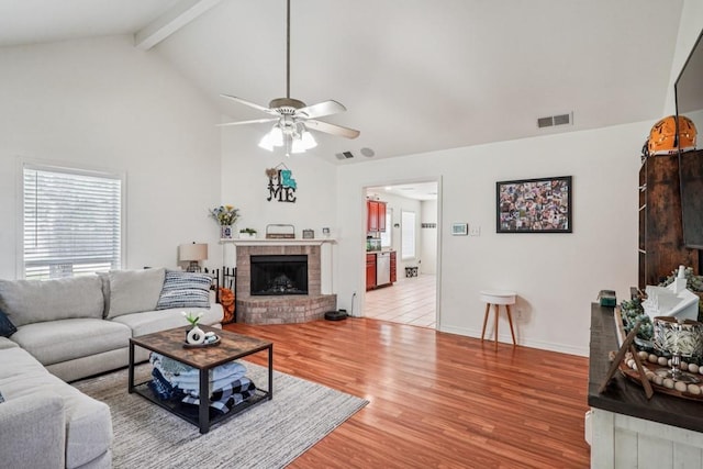 70105 10th St, Covington, LA 70433 - living room with a fireplace, a ceiling fan, wood finished floors, beamed ceiling, and high vaulted ceiling