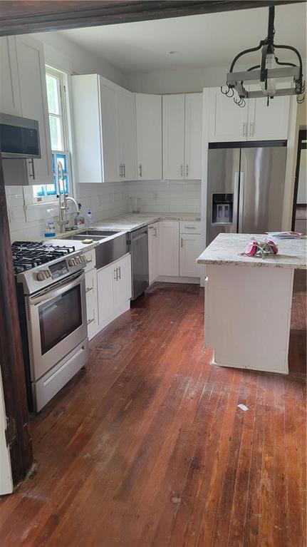 177375 N Dorgenois St, New Orleans, LA 70119 - kitchen featuring stainless steel appliances, dark wood-type flooring, a chandelier, and decorative backsplash