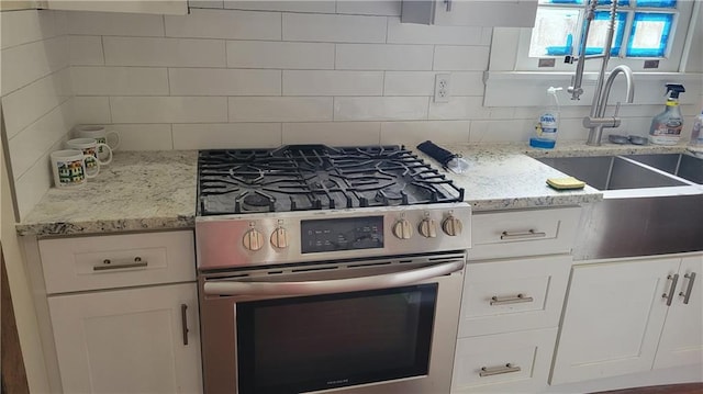 177375 N Dorgenois St, New Orleans, LA 70119 - kitchen featuring stainless steel gas stove, white cabinets, backsplash, and light stone countertops