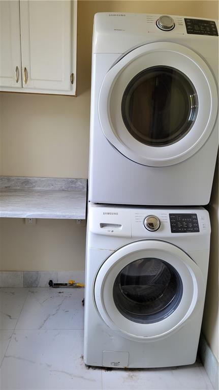 177375 N Dorgenois St, New Orleans, LA 70119 - laundry room with stacked washer / drying machine, cabinet space, and marble look tiles