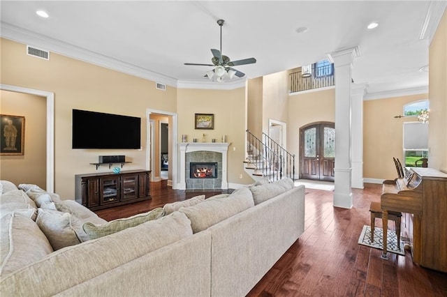 412 Aspen Ln, Covington, LA 70433 - living room with decorative columns, a ceiling fan, crown molding, dark wood-style floors, and a tiled fireplace