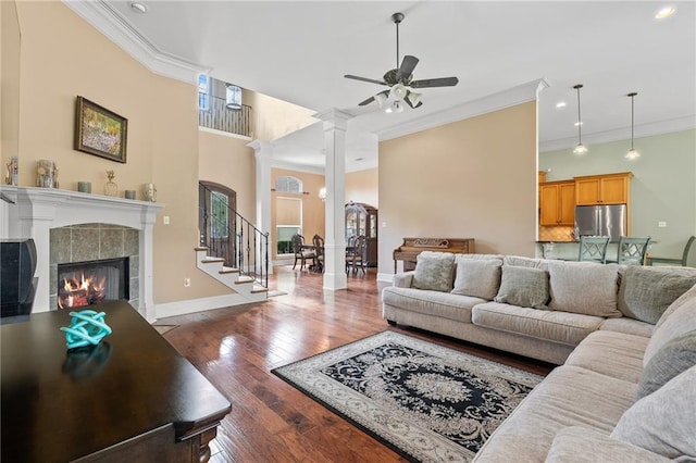 412 Aspen Ln, Covington, LA 70433 - living area featuring ornamental molding, a ceiling fan, a fireplace, dark wood-type flooring, and ornate columns
