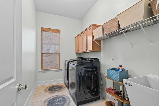 412 Aspen Ln, Covington, LA 70433 - washroom featuring independent washer and dryer, light wood-style flooring, and cabinet space