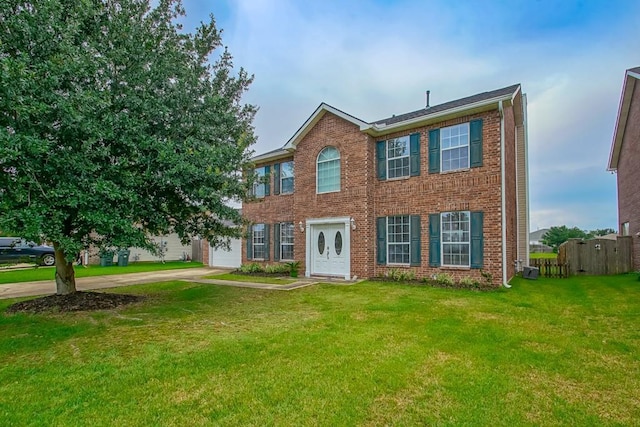 784 Lakeview Ln, Covington, LA 70435 - colonial house featuring concrete driveway, brick siding, a front yard, and a garage