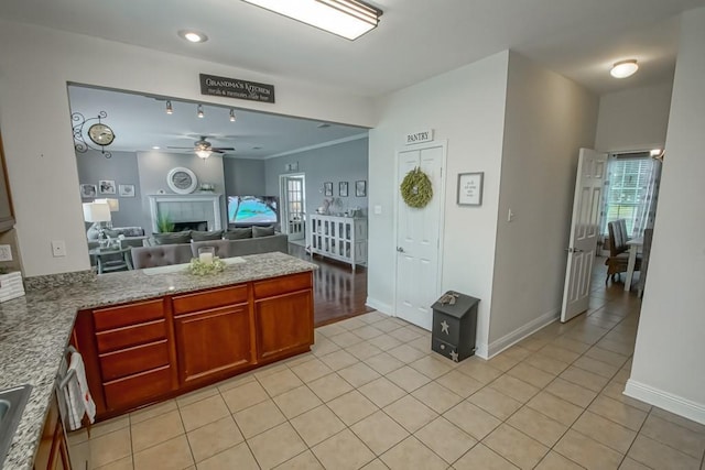 784 Lakeview Ln, Covington, LA 70435 - kitchen with a ceiling fan, a peninsula, open floor plan, a tiled fireplace, and light tile patterned flooring